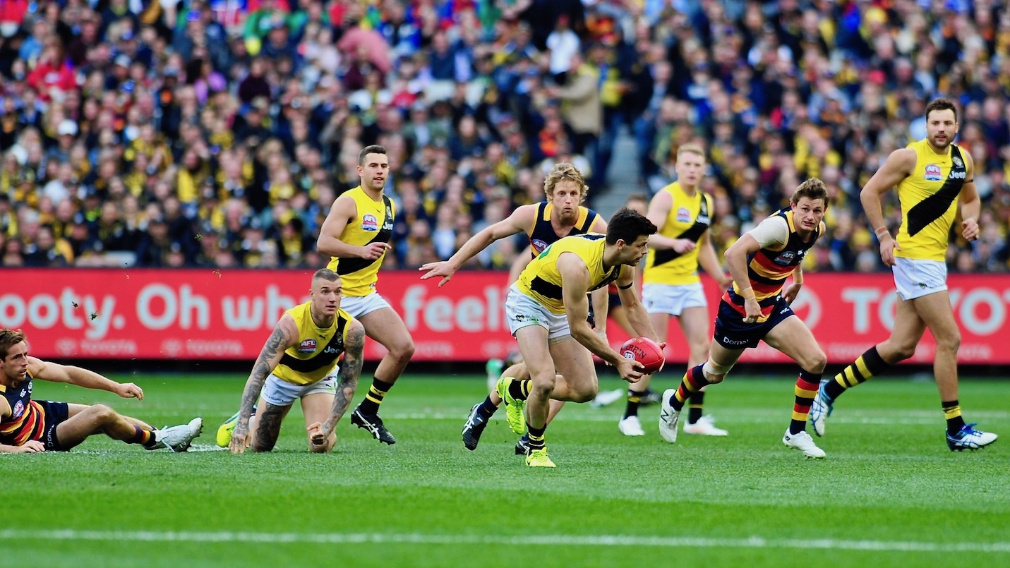 Cotchin recieves from Martin as Matt Crouch gives chase 