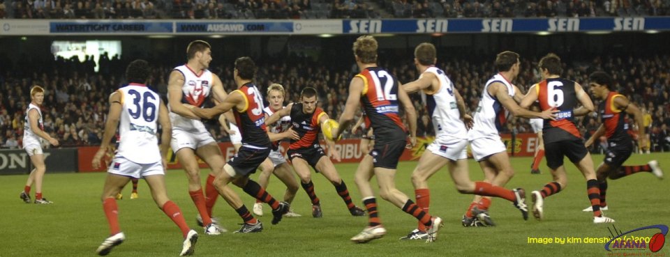 Essendon work the ball through heavy traffic after a center bounce.