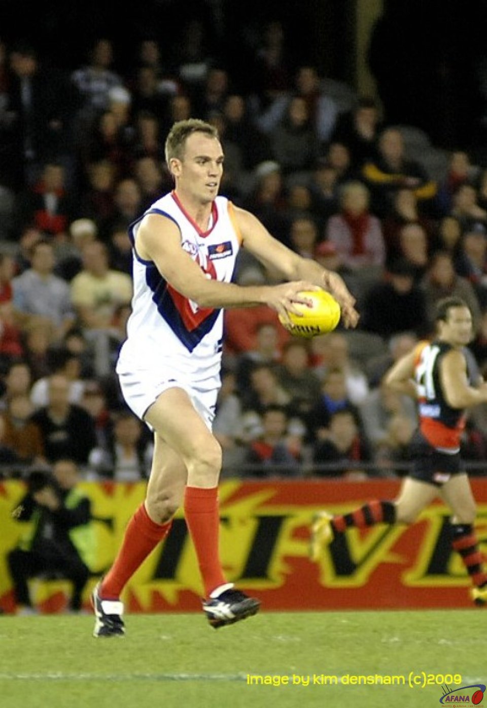 Melbourne Demon  running the ball out of defence
