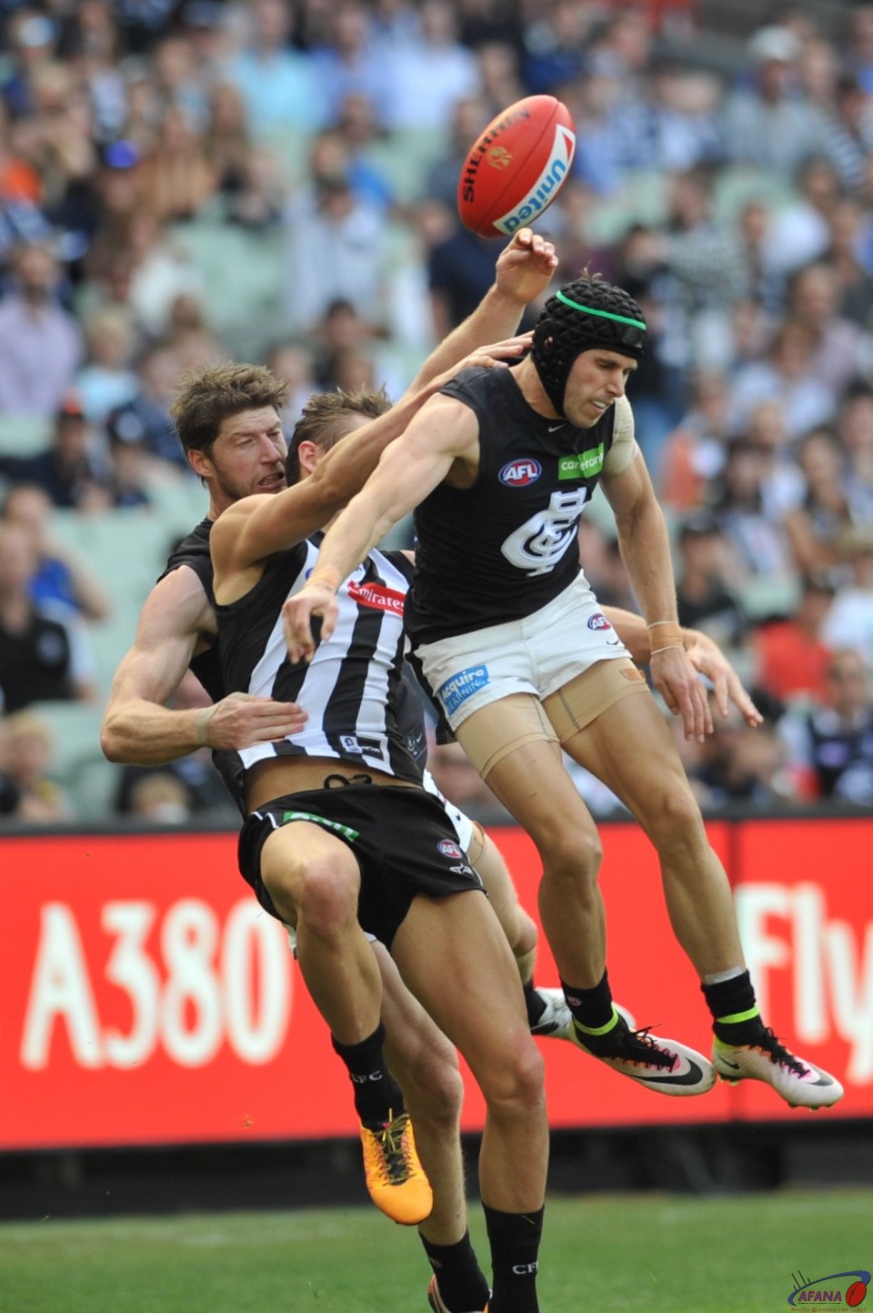 Darcy Moore gets crunched by Carlton skipper Marc Murphy and defender Sam Rowe