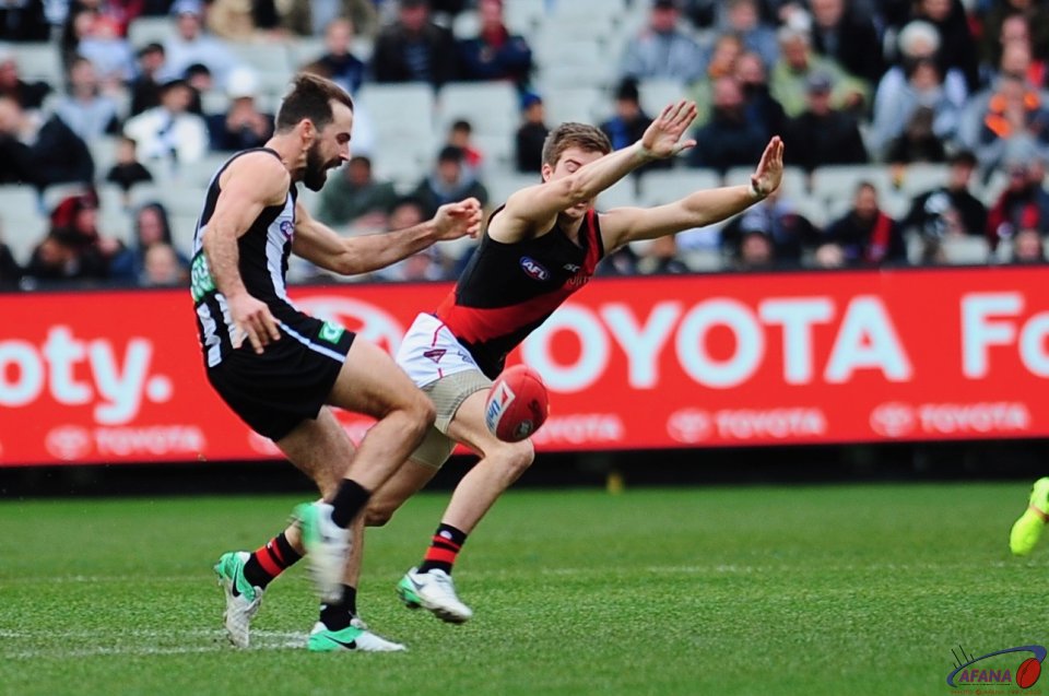 Zac Merrett attempts to smother Steele Sidebottom's clearance kick