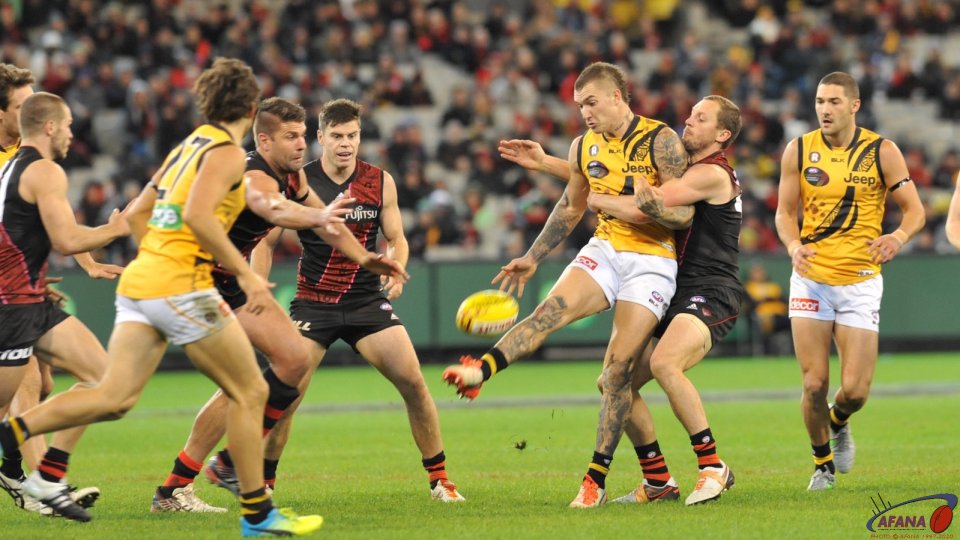 Dustin Martin is tackled by former Geelong premiership player James Kelly