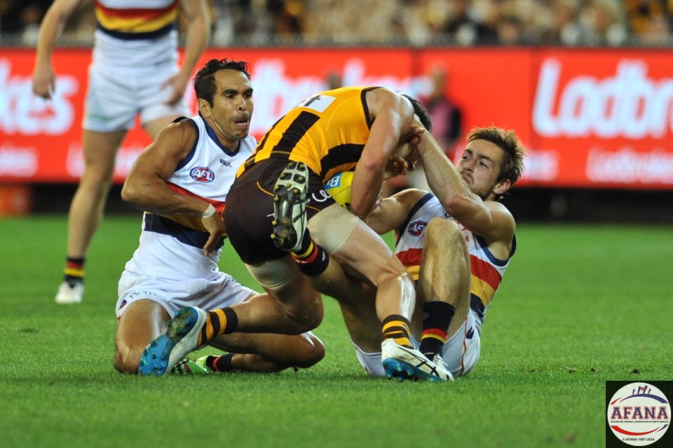 Jordan Lewis is tackled by Brodie Smith and Eddie Betts in support