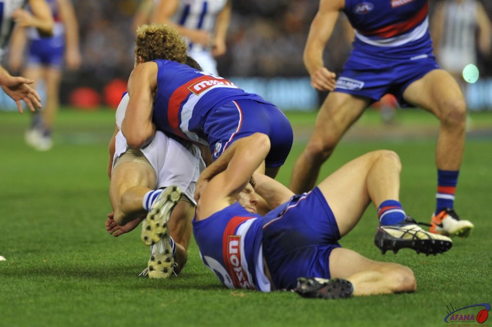 Boomer Harvey is tackled by Mitch Wallis as Matthew Boyd nurses a knock to the head