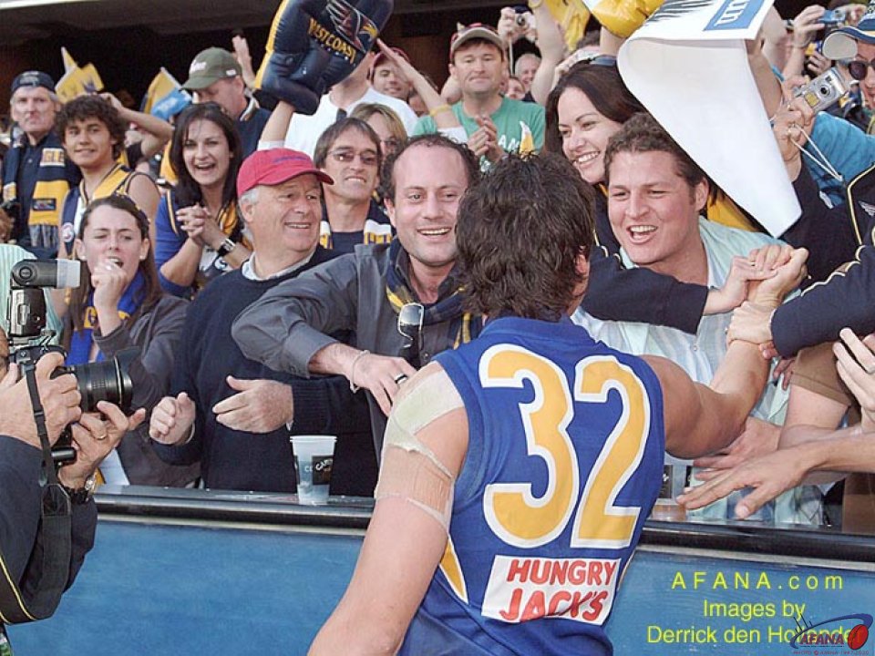 [b]Norm Smith medallist at the 2006 AFL Grand Final, Andrew Embly, is congratulated by family and friends during the victory lap