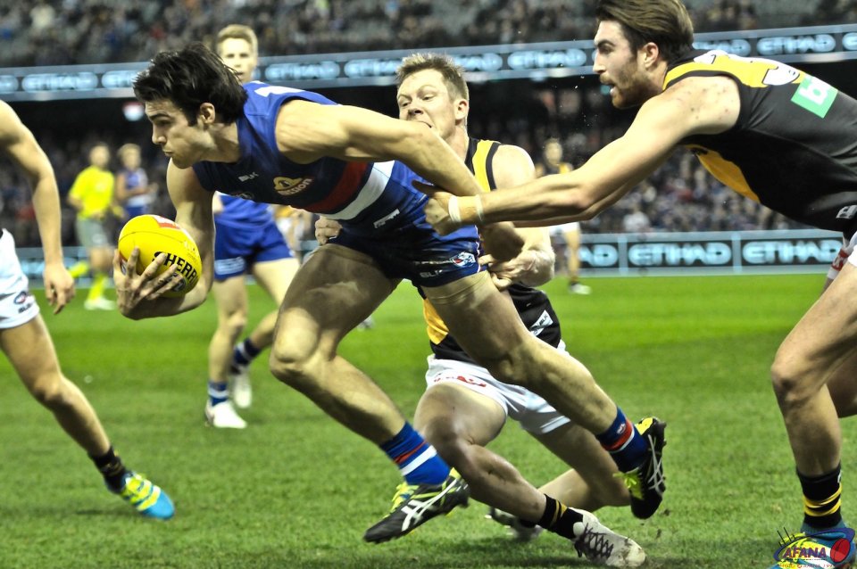 Easton Wood is tackled by Jack Riewoldt and Liam McBean