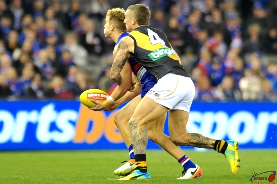 Mitch Wallis is tackled by Dustin Martin