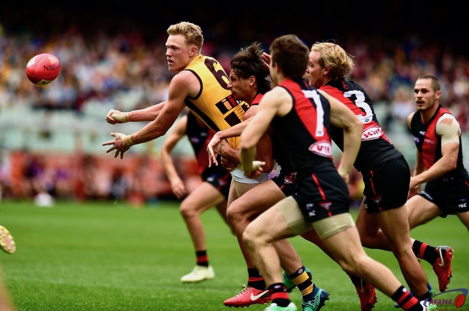 James sicily mobbed by four Bombers handballs forward keeping the pressure on the Bombers defence.