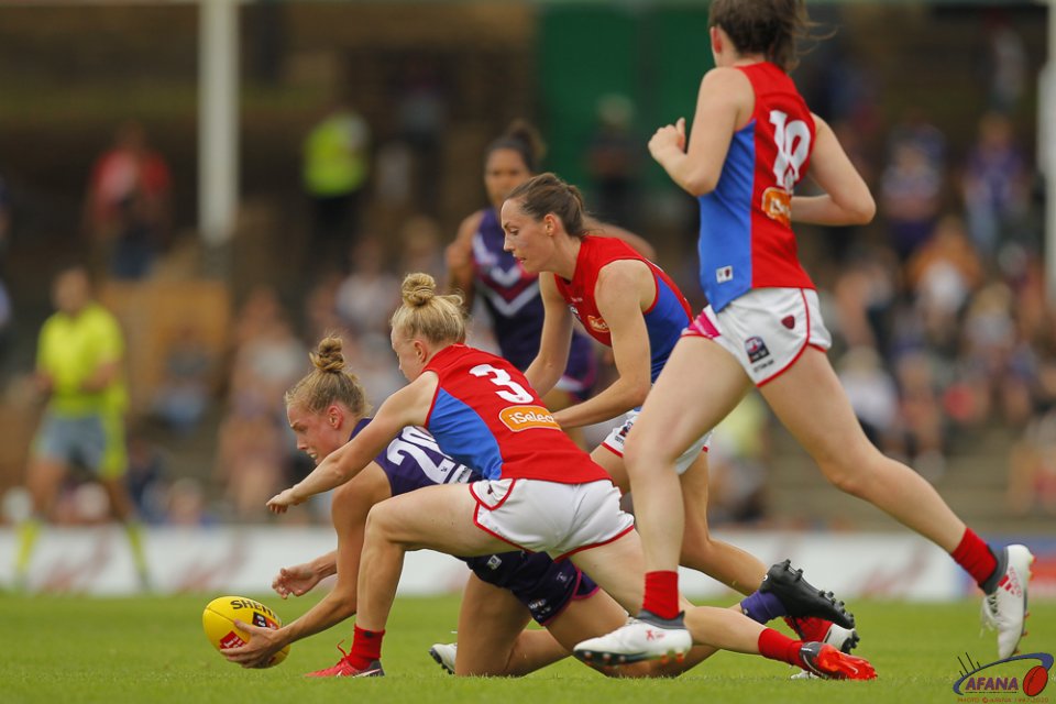 Stephanie Cain of the Fremantle Dockers and Emma Humphries of the Melbourne Demons fight for the ball