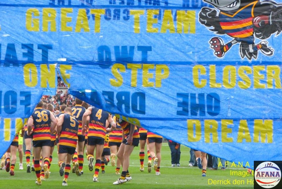 [b]The Adelaide Crows run through their cheersquad banner prior to the match[/b]