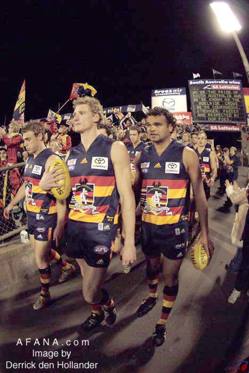 [b]Adelaide Crows players follow their captain onto the field of battle[/b]