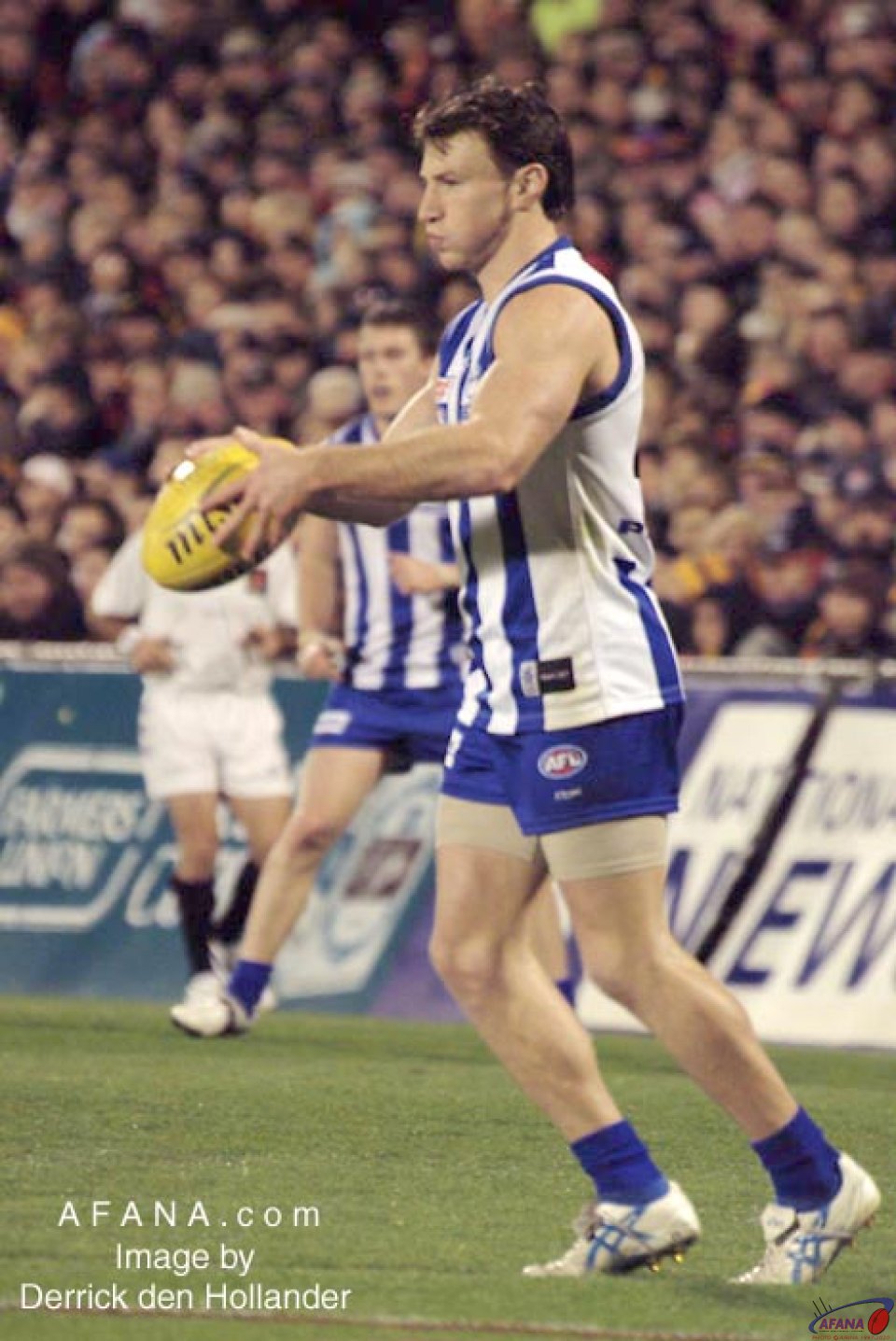 [b]North Melbourne's Brett Harvey about to attempt a short pass after another hard fought posession[/b]