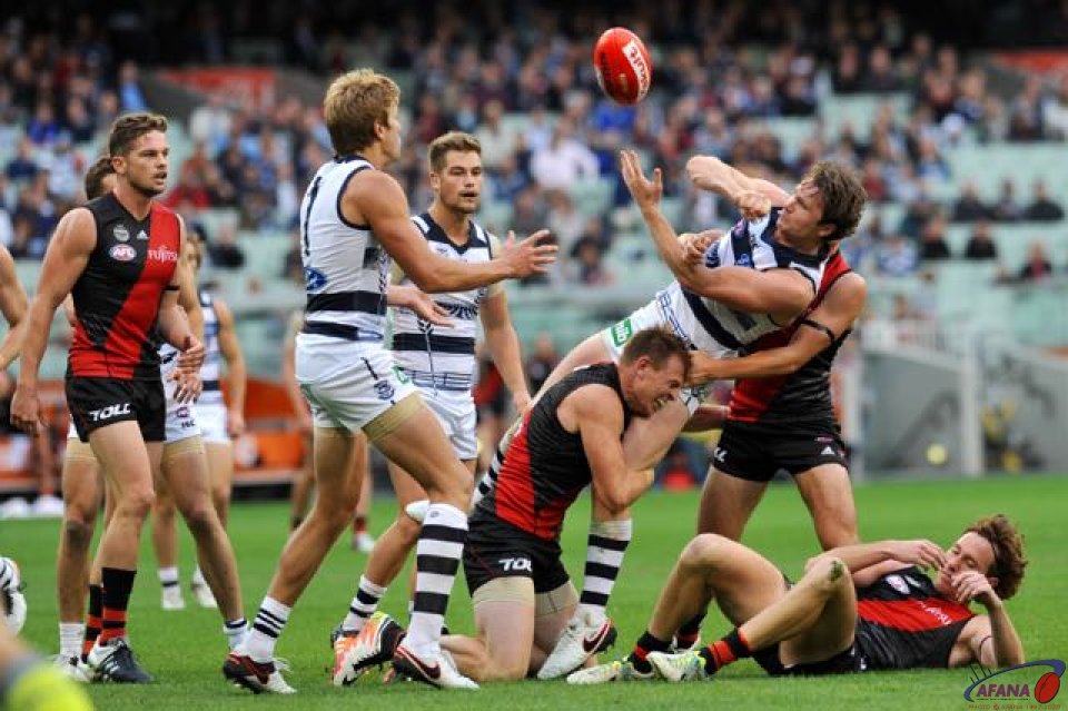 Dangerfield releases the handball to Rhys Stanley while being tackled by Bomber Brendon Goddard