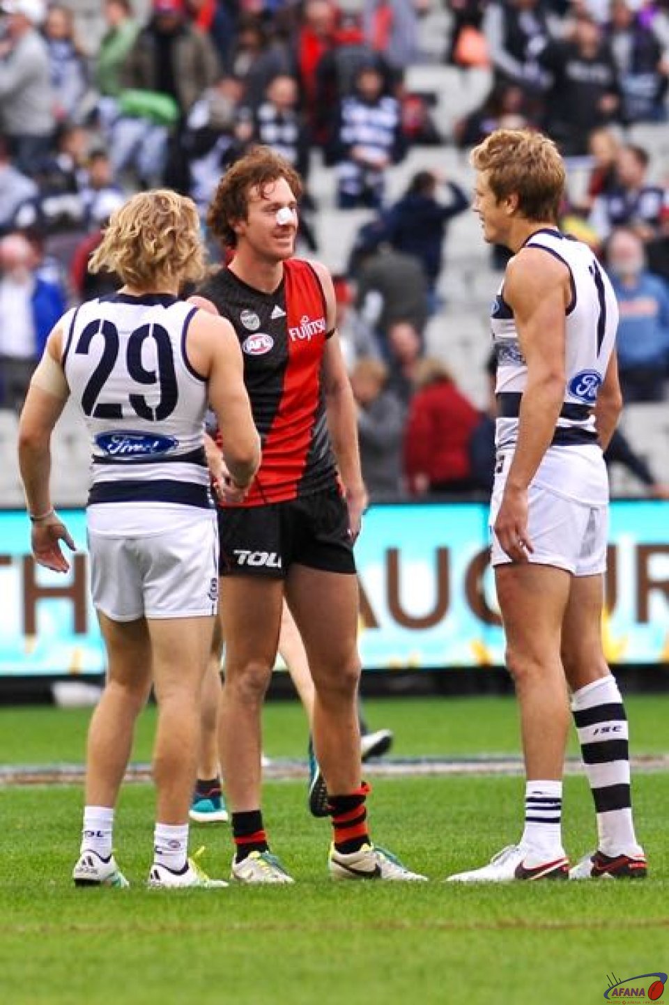 Mitch Brown with a broken nose chats to Cameron Guthrie (28) and