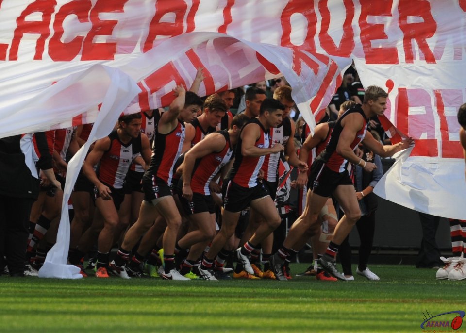 St Kilda led by skipper Nick Riewoldt burst through the banner before their clash with Collingwood