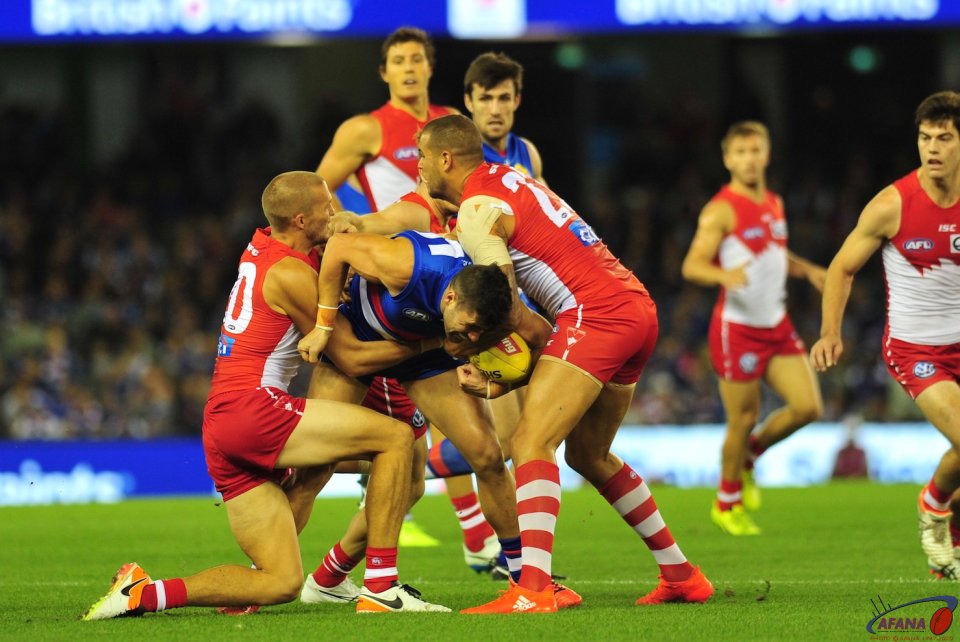 Tom Campbell is tackled by Buddy Franklin (r) and Sam Reid (l)