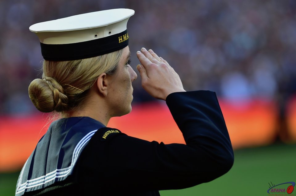A Sailor salutes during the National Anthem